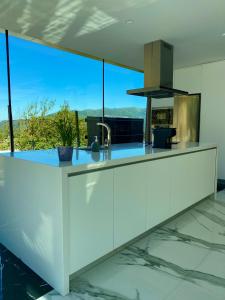 a kitchen with white cabinets and a large window at Oak Nature in Vieira do Minho