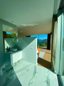 eine Küche mit Arbeitsplatten aus Marmor und Blick auf einen Balkon in der Unterkunft Oak Nature in Vieira do Minho
