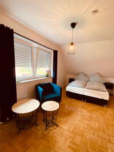 ein Schlafzimmer mit einem Bett, zwei Tischen und einem Stuhl in der Unterkunft Ferienhaus am Seedeich in Emden