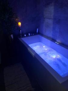 uma banheira azul num quarto escuro em LIKE HOME 2 Sauna,Jacuzzi & Spa em Świdnica