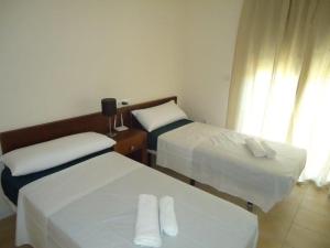Dos camas en una habitación de hotel con toallas. en Casa Patrick, en Murcia