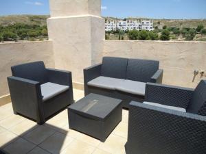 un patio con 2 sillas, un sofá y una mesa en Casa Patrick, en Murcia