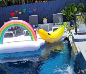 a pool with a slide and a bunch of bananas at Casa806 Men Only Guest House in Fort Lauderdale