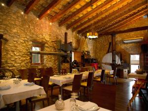 a restaurant with tables and chairs in a stone building at Mas Masdeu in L'Aldea