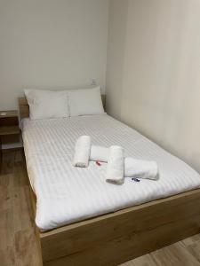 a bed with white sheets and two towels on it at Apartament na Skarpie in Zator