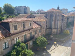un antiguo edificio de piedra con una iglesia en una ciudad en PENSIÓN SANTA CLARA, en Pontevedra