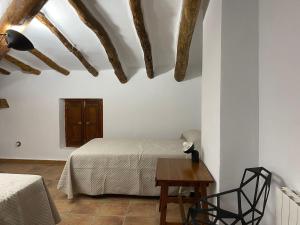 a bedroom with a bed and a wooden table at Casas Mulero Y Pastor in Férez