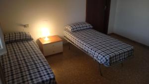2 Betten in einem Zimmer mit einer Lampe auf einem Nachttisch in der Unterkunft Relax al mare in Silvi Paese
