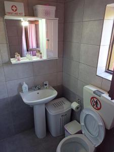 a small bathroom with a sink and a toilet at Casa Con Vista Apartments in Halki