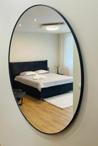 a mirror reflecting a bed in a bedroom at S&A apartamentai in Panevėžys