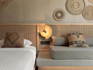 a bedroom with two beds and a couch and plates on the wall at NERĒA Boutique Hotel in Plakias