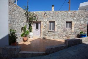 a stone house with a stone wall and a door at Vicky's House in Kos
