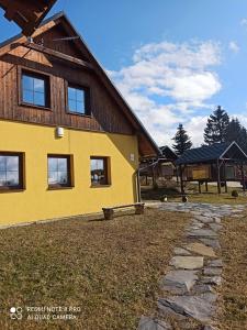 una casa amarilla con una pasarela de piedra delante de ella en Kemp Indiana, en Edrovice