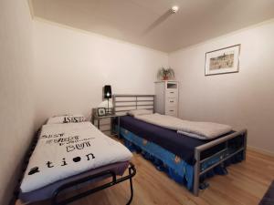a bedroom with two beds and a dresser in it at Tofta Konstgalleri-Familjelägenhet in Varberg