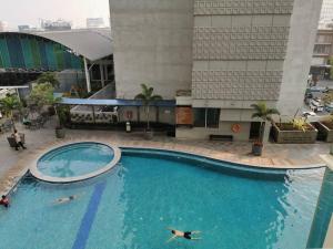 een groot zwembad voor een gebouw bij Two Bedroom Apartment at el Royale Hotel in Bandung