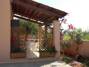 a wooden pergola with a table and chairs under it at Marsala Casa Vacanza Villetta in Marsala