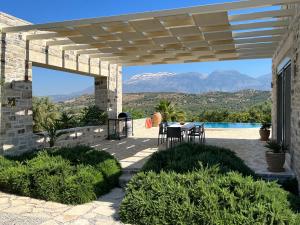 a patio with a table and a view of the mountains at Villa Lemoni in Kamilari