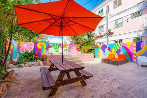 a picnic table with an umbrella in front of a wall at Wynwood Boutique Hotel in Willemstad