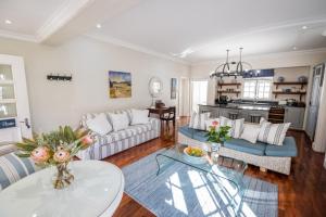 a living room with a couch and a table at Admiralty Beach House in Port Elizabeth