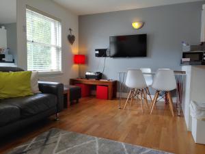 a living room with a couch and a table and chairs at The Bath House Apartments - Free 1st breakfast - FREE parking in Bath