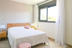 a bedroom with a white bed and a window at Seashell Infinity Luxury Apartment in Estepona +30 photos