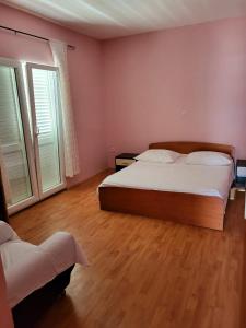 a bedroom with a large bed and two windows at Apartment Raslina in Raslina