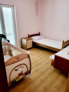 two beds in a room with wooden floors at Apartment Raslina in Raslina