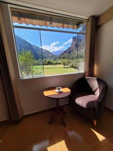 a room with a window with a couch and a table at Ayllu B&B Ollantaytambo in Ollantaytambo