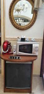 a microwave on a table in front of a mirror at Regina Suite in Brindisi
