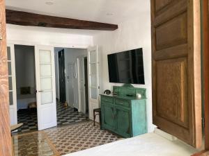 sala de estar con TV y armario verde en La Casa de Lea, en Béjar