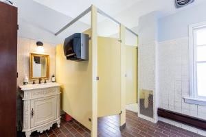 a bathroom with a sink, toilet and shower at College Inn Hotel in Seattle