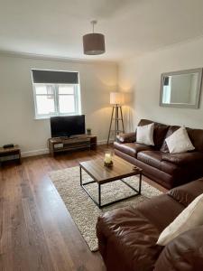 ein Wohnzimmer mit einem Sofa und einem Couchtisch in der Unterkunft Modern 2 bedroom apartment near Glasgow Airport in Paisley