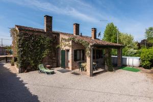 a brick house with ivy growing around it at Country house Viaro_150sqm in Vanzo