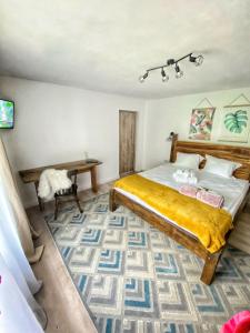 a bedroom with a large bed and a table at Casa Her in Galaţi