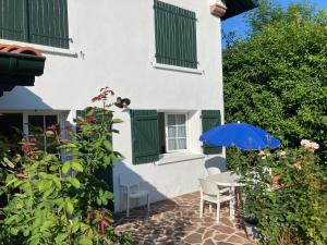 a patio with a table and a blue umbrella at Saint Jean Pied de Port: Nere Nahia in Saint-Jean-Pied-de-Port +4 photos