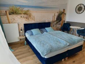 a bedroom with a blue bed and a beach at Porta Mare Marine in Dziwnów