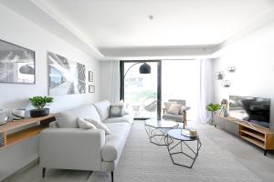 a white living room with a couch and a table at Seashell Infinity Luxury Apartment in Estepona