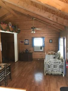 a living room with wooden walls and a ceiling at A Peace of Heaven Cabins and RV in Vanderpool