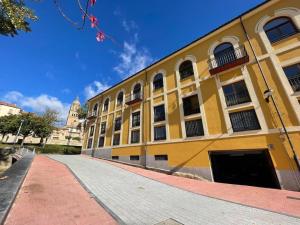 un gran edificio amarillo con una acera delante de él en Vivienda de uso turístico Domus Josefae, en Salamanca