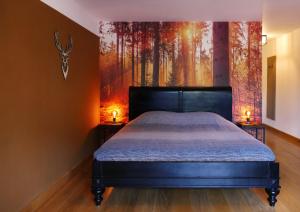 a bedroom with a bed and a painting of trees at B&B Zondag in Eys