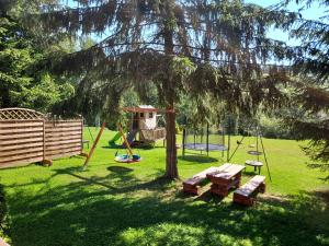 a park with a playground with a picnic table and a tree at Noclegi nad Czarną Orawą in Podwilk
