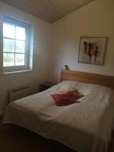 Un dormitorio con una cama blanca con un vestido rojo. en Lønne Feriepark Holiday House 53, en Lønne Hede