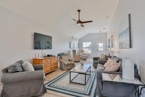 a living room with two couches and a tv at Athenas Cottage in Butler Beach