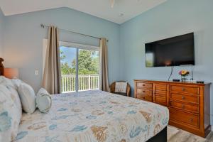 una camera da letto con un letto e una grande finestra di Walk to Beach with Private Pool, Balconies & Huge Lawn Blocks to Dining a Butler Beach Altre 40 foto