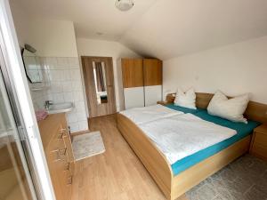 ein kleines Schlafzimmer mit einem Bett und einem Waschbecken in der Unterkunft Appartement Christian in Bad Kleinkirchheim