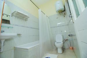 uma casa de banho branca com um WC e um lavatório em Al-Nisaa Hotel and Spa em Jinja