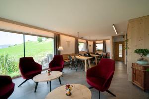 Pokój ze stołami i krzesłami oraz dużym oknem w obiekcie Oberzerod Apartments w mieście Siusi