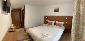 a bedroom with a bed with two towels on it at Casa Luca in Ceahlău
