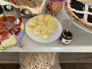 una mesa con un plato de queso y un pastel en B&B Casa Losea, en Castello delle Forme