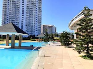 a large swimming pool in a city with tall buildings at Dan's Cool Suites Tagaytay in Tagaytay